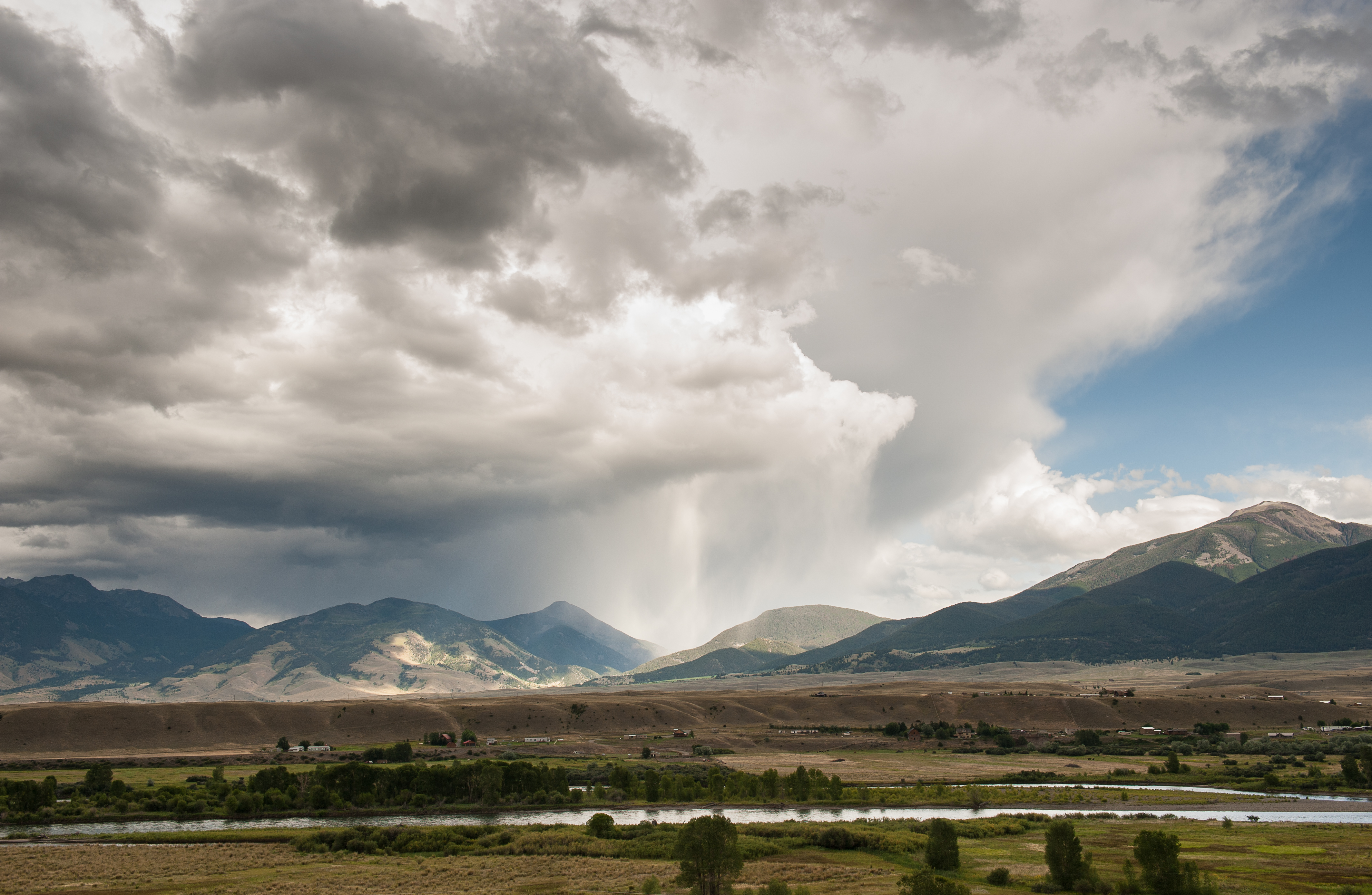 Paradise Valley, Moutain Range with Storm over head with green fields and houses in front of it